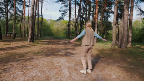 mujer disfrutando de un día de primavera en el bosque