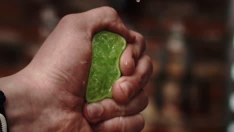 Close-up-handheld-video-of-hand-squeezing-lime