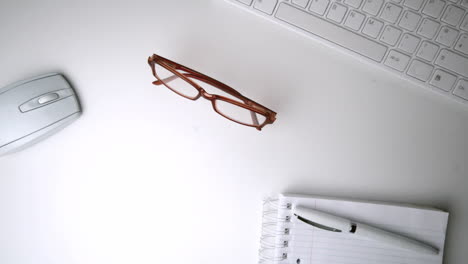 red glasses falling onto an office desk