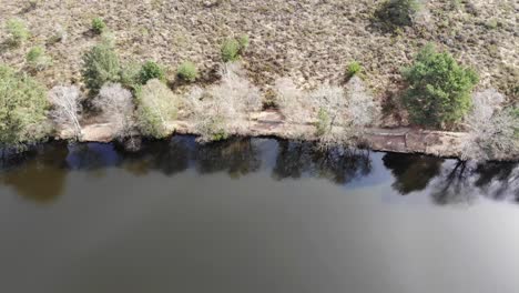 Aerial-Overhead-View-Along-Embankment-Of-Squabmoor-Reservoir-Located-In-Woodbury-Common,-Devon