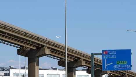 monorail and plane taking off in background, outskirts of haneda airport