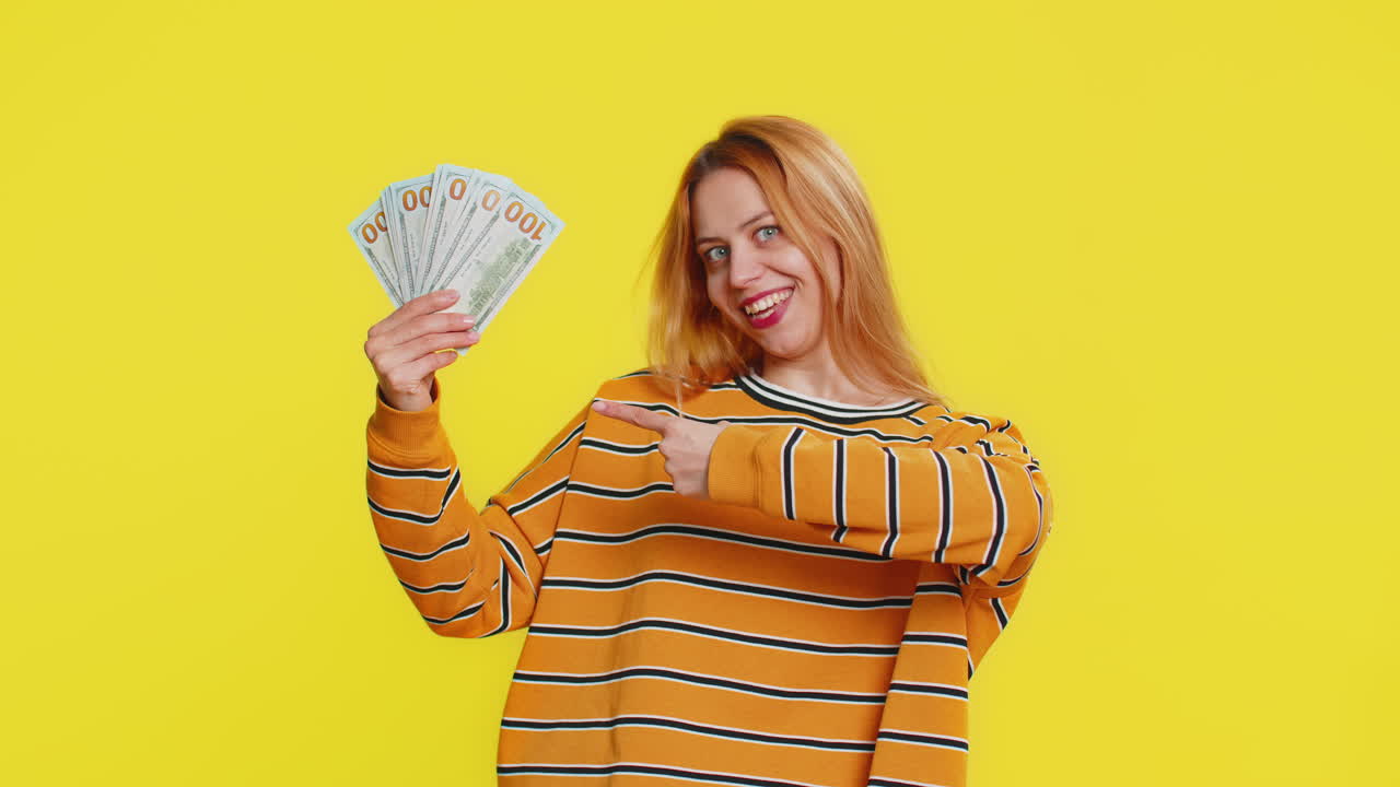 Rich happy woman winner waving money dollar cash like a fan big income wealth success business