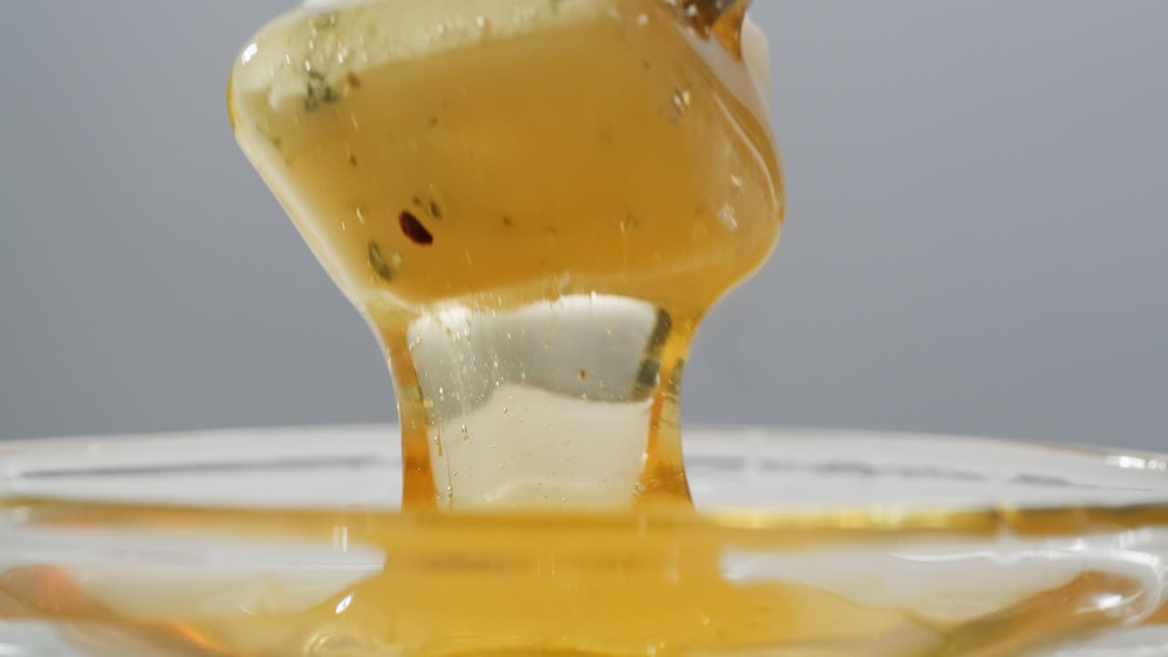 Tasty blue cheese with rosemary, honey and walnuts on white table, close up of Dorblu in cafe pouring in honey.