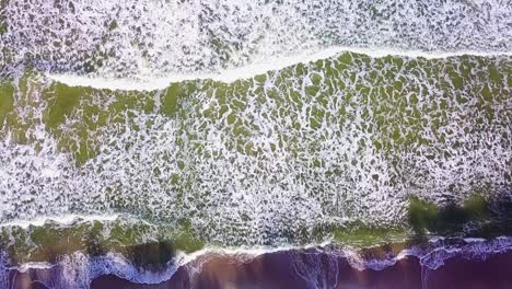 ocean waves rolling on beach top down aerial view