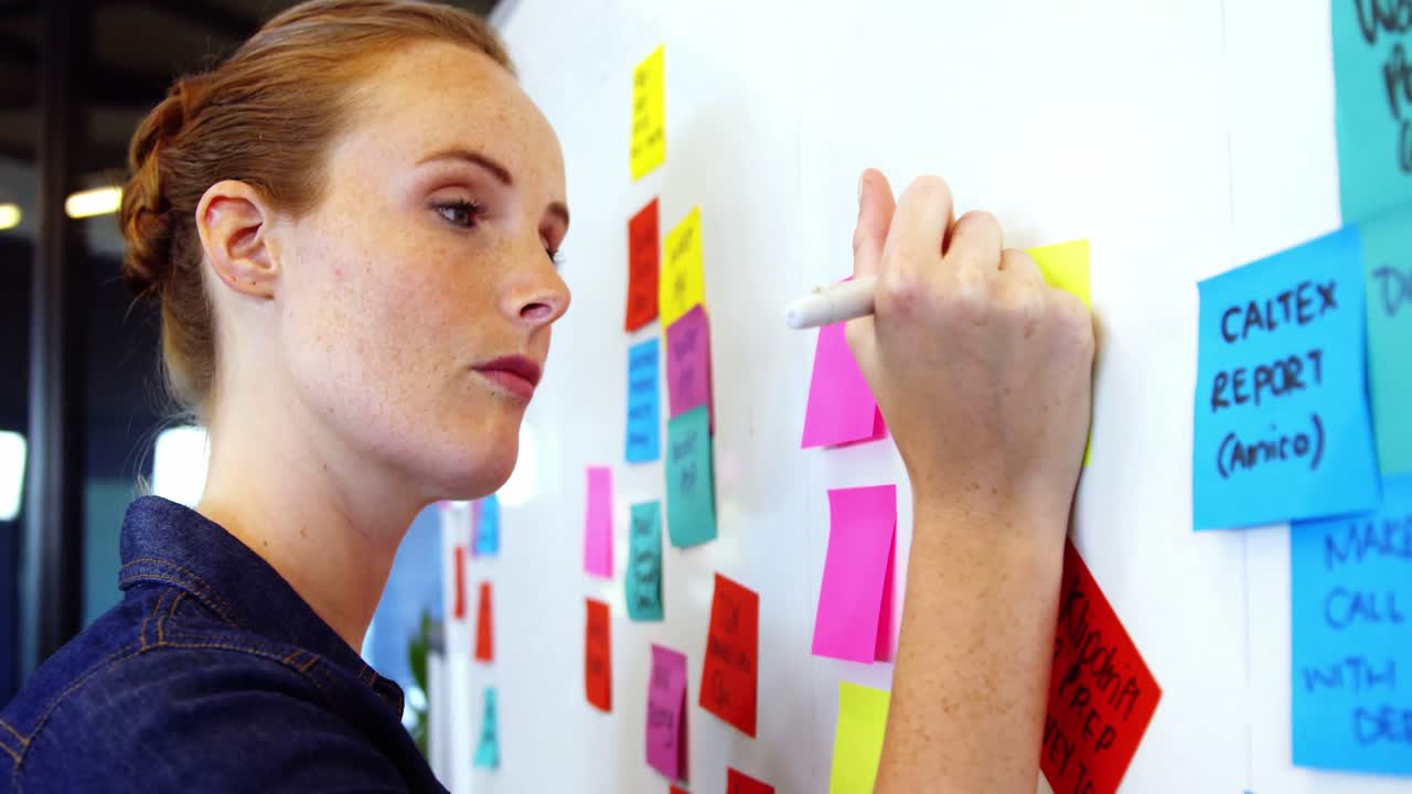 ejecutiva de negocios escribiendo en notas adhesivas