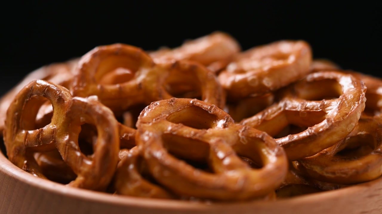 Bol de bretzels en rotation sur une table en gros plan, concept de collation.