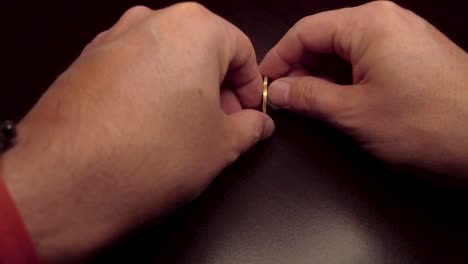 10 pesos coin spinning by hand on a wooden table