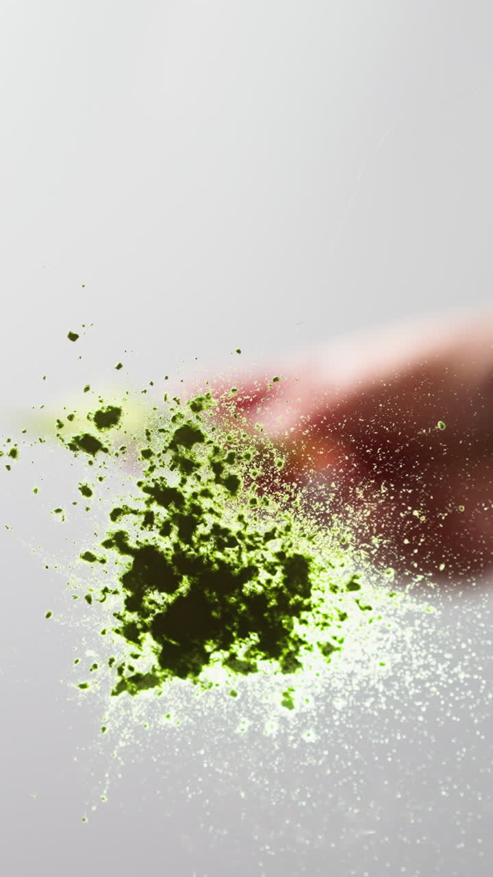 крупный план руки с зеленым блеском, эффект замораживания кадра на светлом фоне