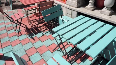 blue and red cafe table and chairs on a cobblestone patio