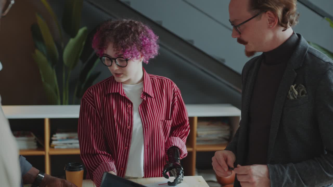 Female Team Leader with Prosthetic Arm Holding Office Meeting with Colleagues
