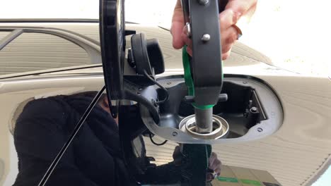 mujer abasteciendo de combustible en la bomba de la gasolinera en un día soleado