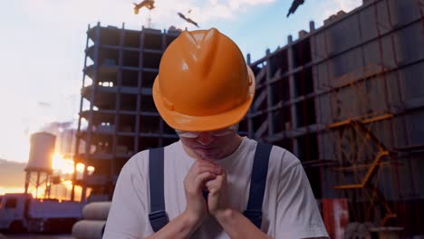 un hombre asiático orando por algo en el sitio de construcción.