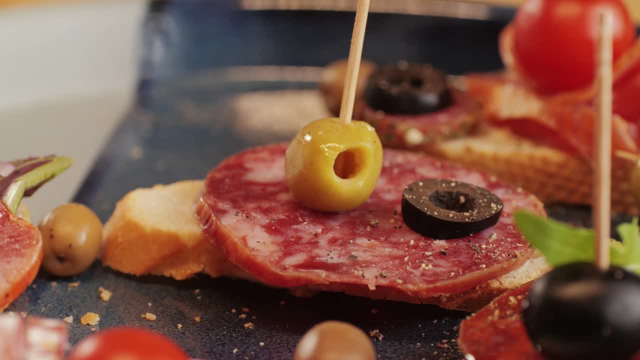 Mix of spanish pork sausages, Cutting board of appetizing catalonian snack - fuet, jamon, chorizo, olives, supermarket tapas food in spain, traditional cuisine.