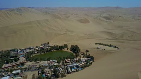 aerial shot over huacachina oasis in the atacama desert, peru