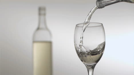 white wine flowing in super slow motion from a bottle