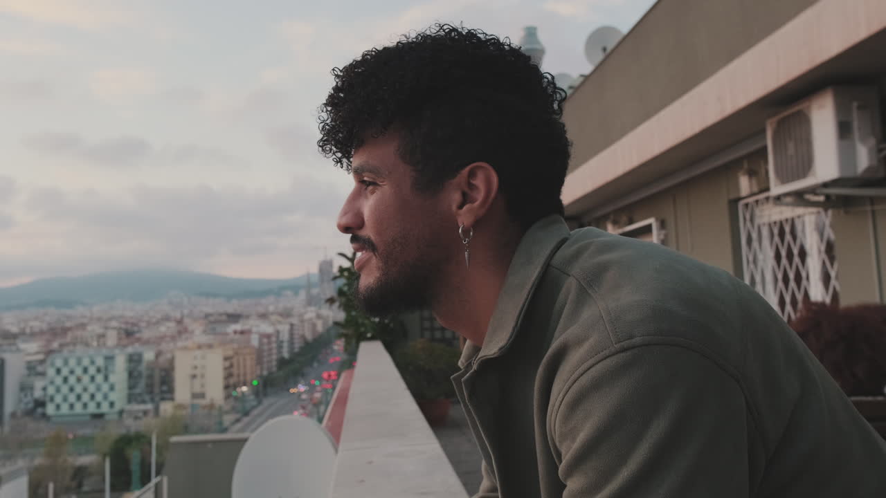Hombre en un balcón en la azotea con vistas a la ciudad