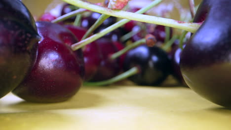 macro dolly out shot of ripe red cherries on table during sunny day