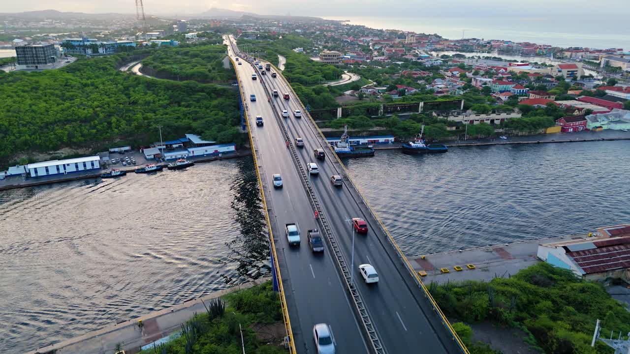 드론은 자동차가  ⁇  줄리아나 다리를 건너고 강 아래에 정박한 견인 보트와 함께 상승합니다.