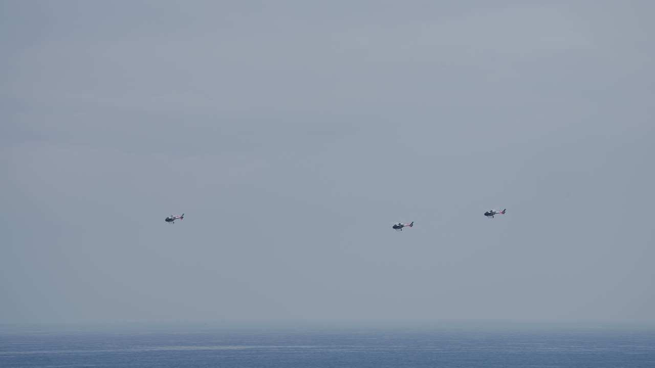 Helicopters flying over the ocean