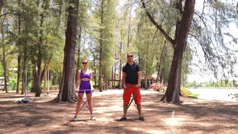 couple workout with resistance bands in the park