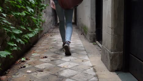 lgtbq female in jeans walking through the hallway with guitar on back