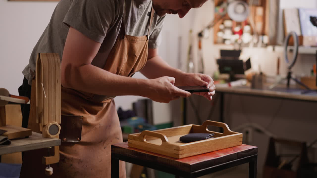 un hombre con barba toma una foto de un elegante bolso de cuero en el estudio