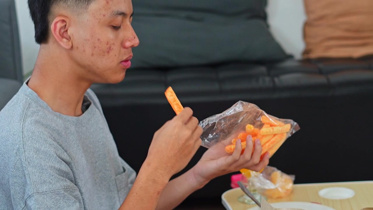 Profilo laterale di un giovane uomo che mangia karedok con riso e patatine fritte
