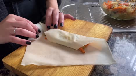 close shot of the hands of a woman doing a spring roll