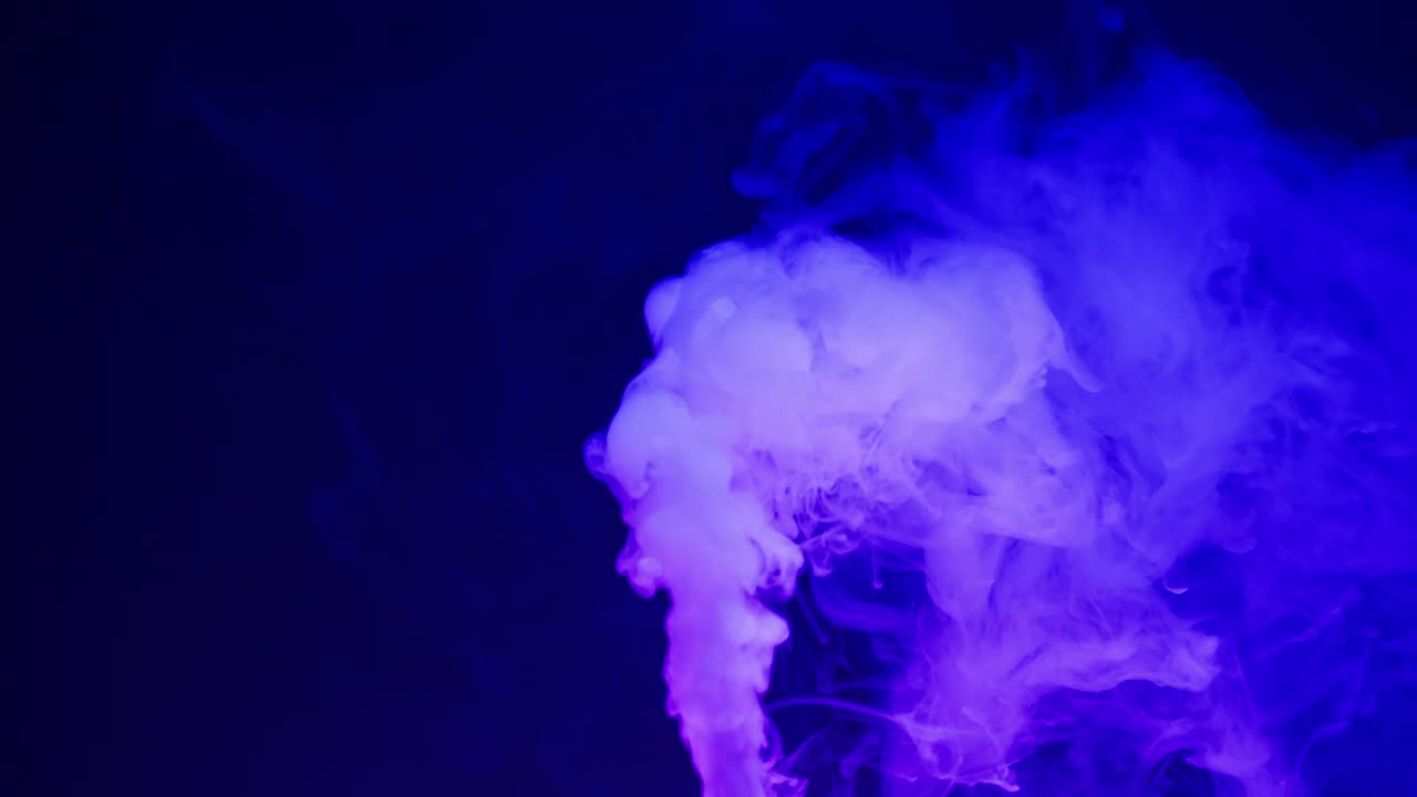 Dynamic Blue and Purple Smoke Swirling on a Dark Background