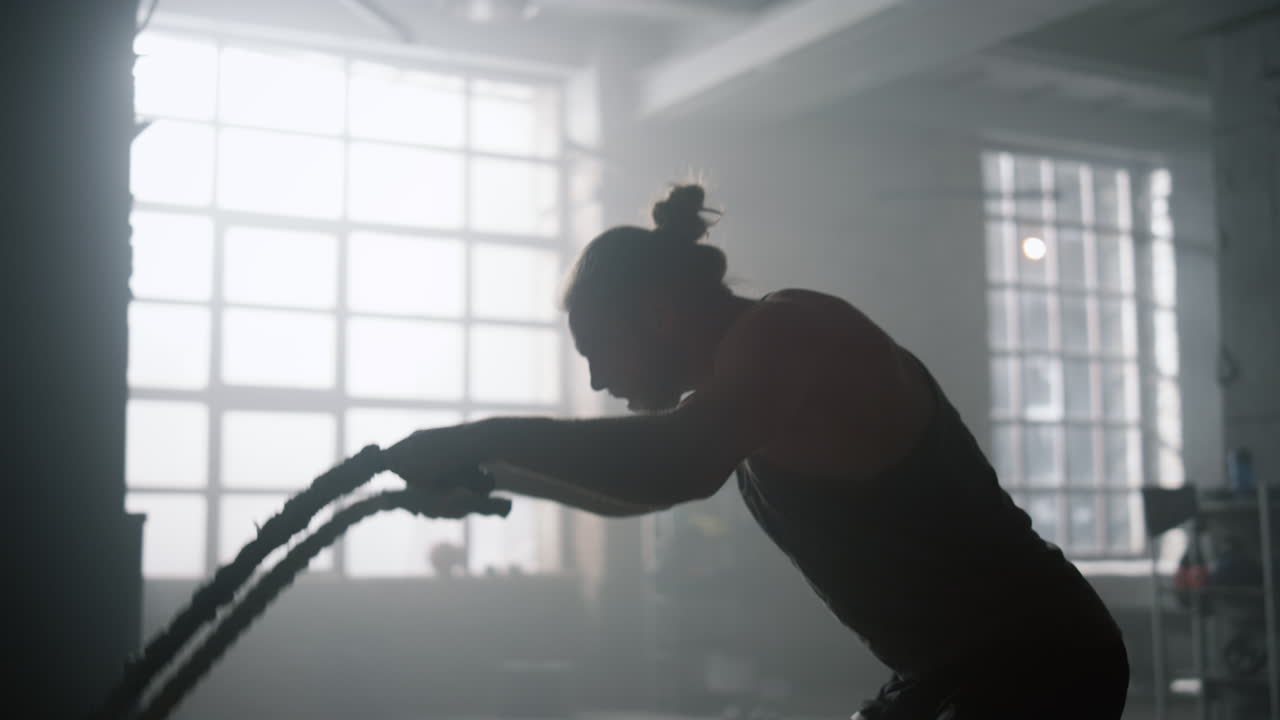 전투 로프로 크로스 피트 운동을 하는 남자. 체육관에서 몸을 훈련시키는 분노한 남자