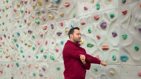 Mann-Kletterer-Dehnt-Sich-Beim-Aufwärmen-Der-Hände-Vor-Der-Wandkletterübung-Auf-Einem-Sportplatz-Im-Freien-Aus