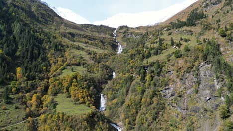 Cascada-Y-Picos-Nevados-En-El-Parque-Nacional-Hohe-Tauern,-Austria---Pedestal-Aéreo-4k