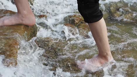 person walking through a shallow stream