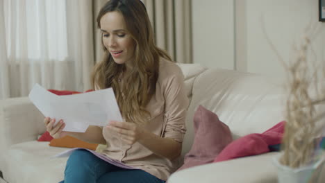 happy woman looking business papers at home. business woman doing paperwork