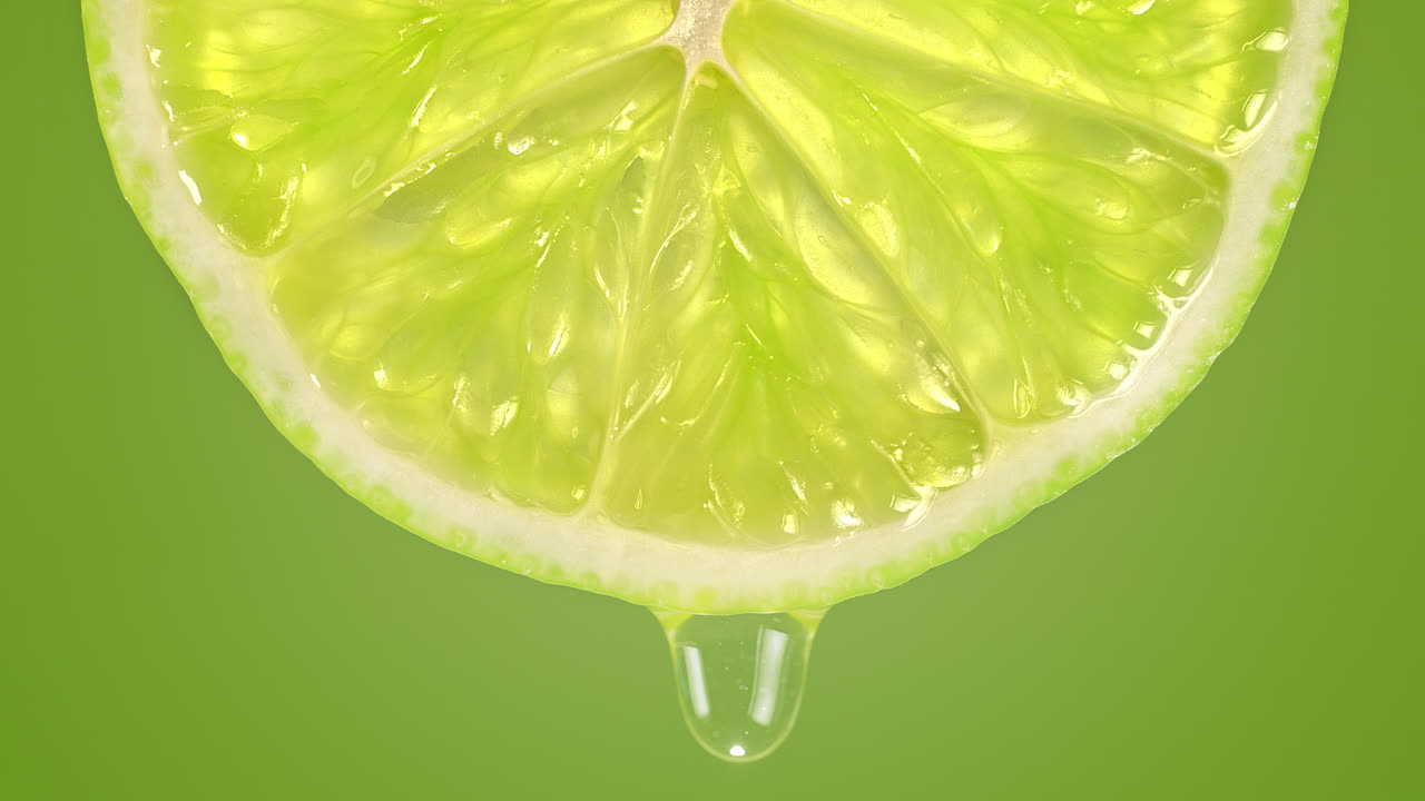 녹색 바탕에 느린 동작으로 라임 슬라이스에서 떨어지는 물방울