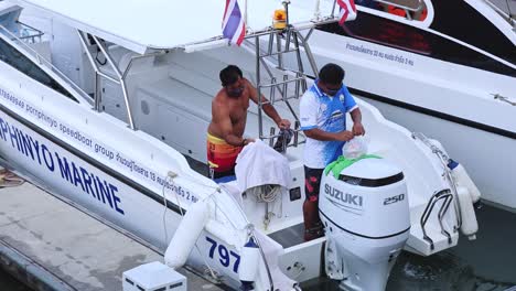 two men working together on a boat's maintenance