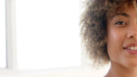 una joven hembra biracial con cabello rizado está sonriendo