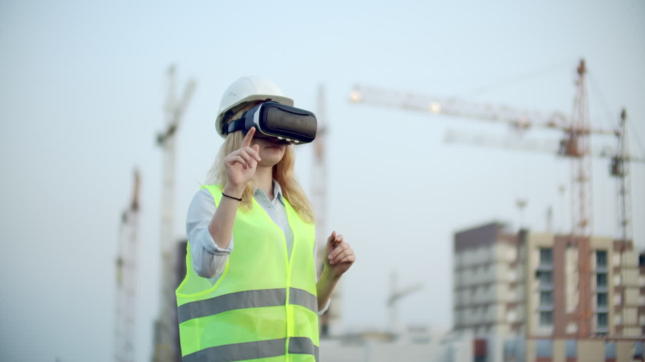 retrato de una operadora de grúa que opera un sitio de construcción usando gafas de realidad virtual. mujer de construcción. gerente gestiona el progreso y el plan de los edificios usando gestos al atardecer