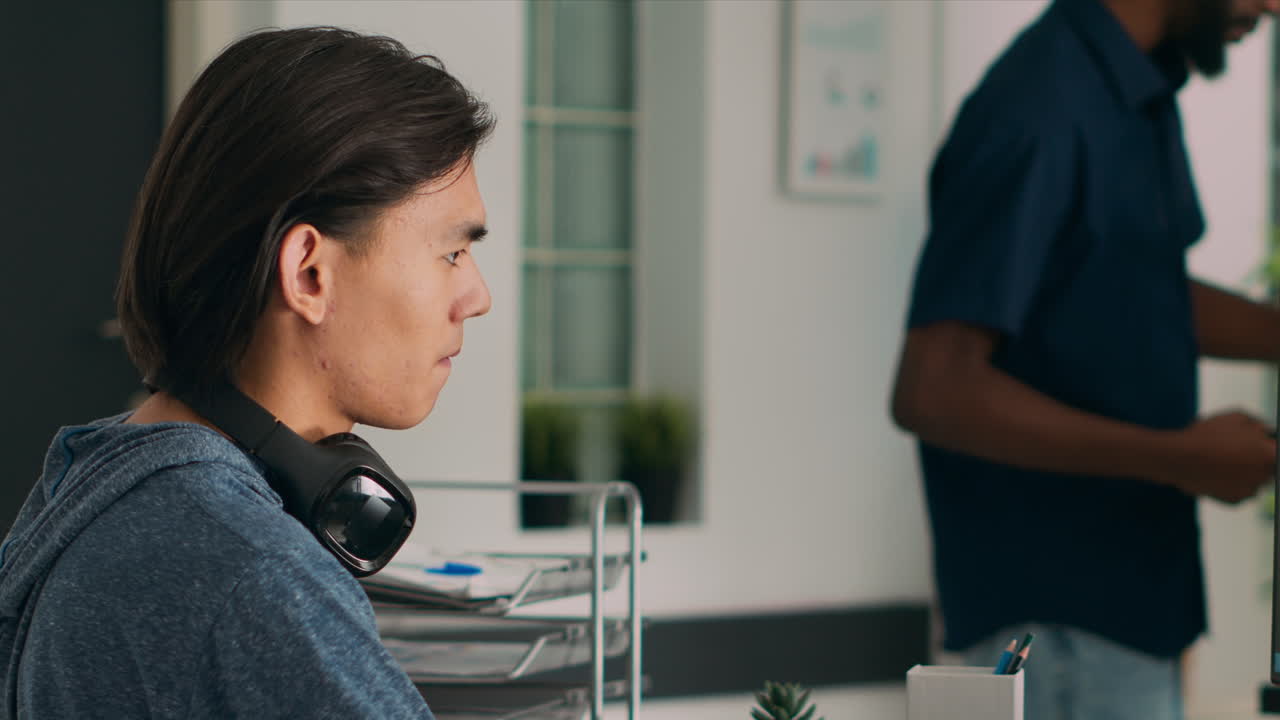 Asian database programer writing code on computer