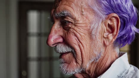 vista de perfil en primer plano de un hombre anciano con cabello púrpura