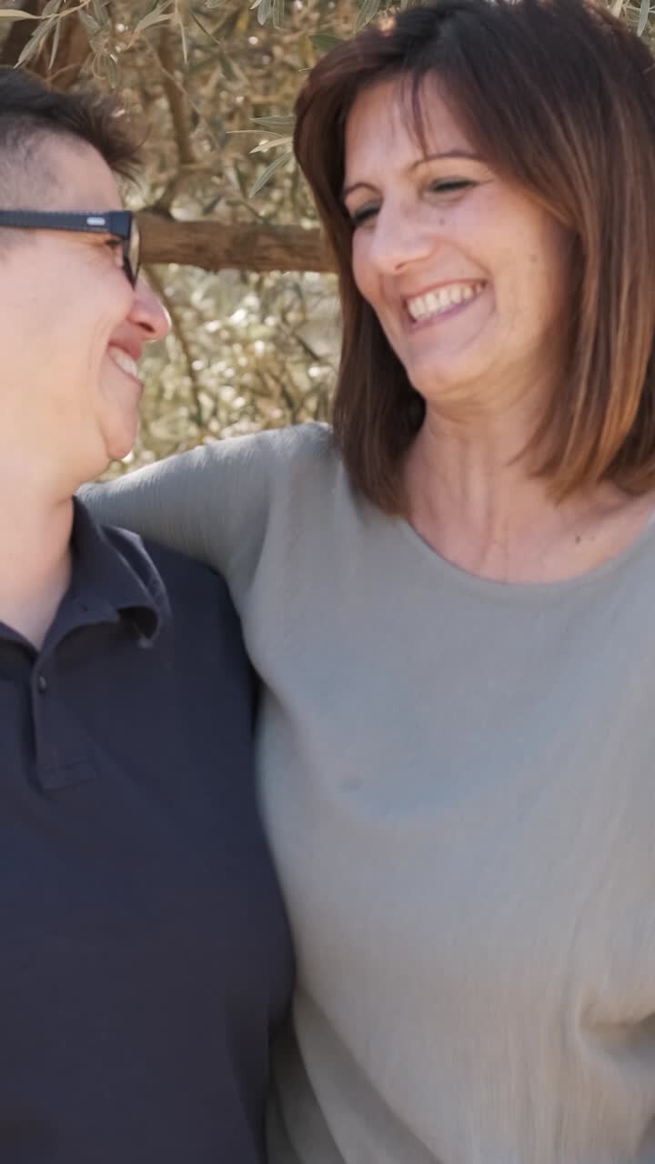Cheerful lesbian couple laughing while embracing outdoors