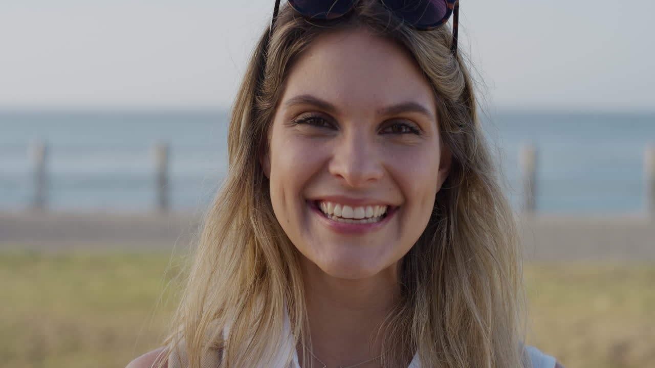 retrato de una joven rubia feliz riendo disfrutando de unas vacaciones mujer exitosa en una soleada playa del océano en cámara lenta