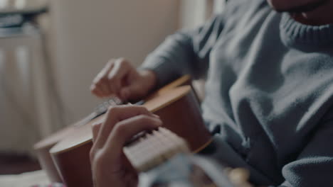 young musician playing the guitar at home