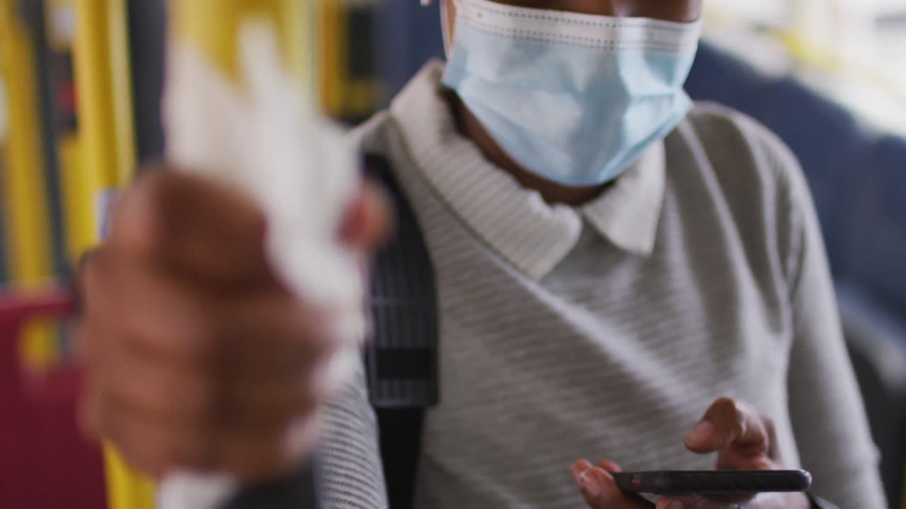 African american businesswoman with face mask standing in bus