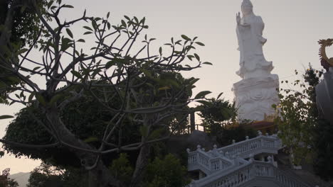 buddhist temple with white statue and gardens