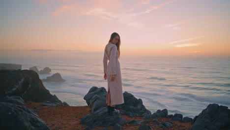 thoughtful woman watching ocean posing cliff alone. girl enjoying marine view