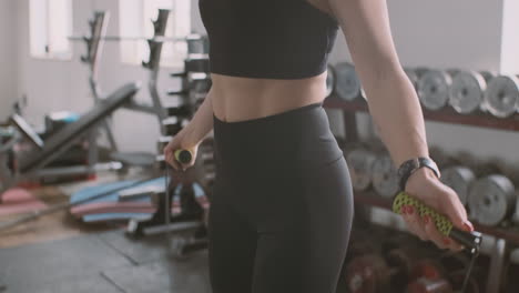 a sportive beautiful female jumps over the rope in the gym