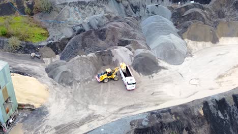 tipper loading lorry with gravel in quarry