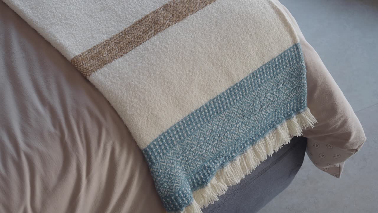 Coperta decorativa bianca e blu su un letto