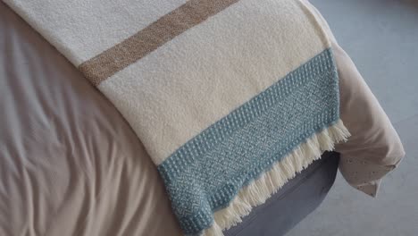 white and blue throw blanket on a bed